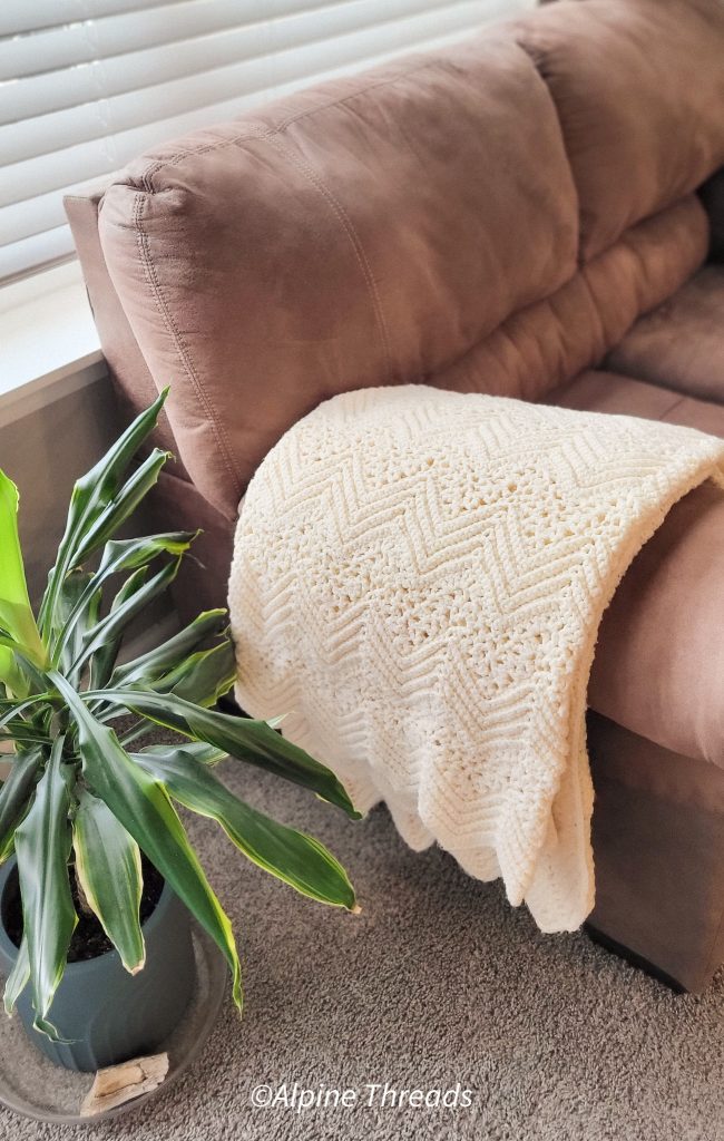 cream colored afghan on sofa