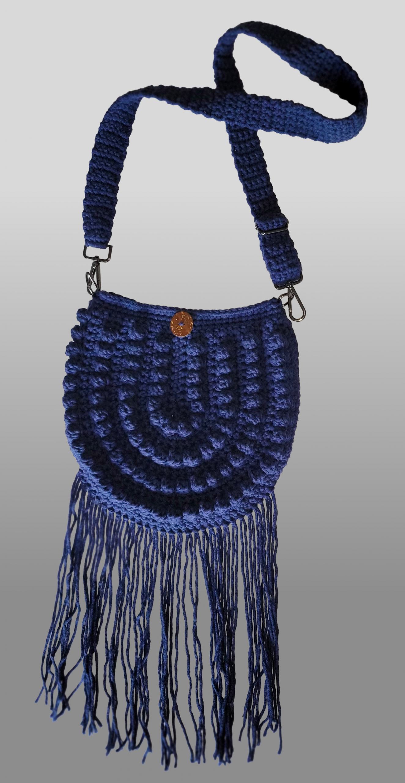 Navy blue crocheted crossbody purse with fringe.
